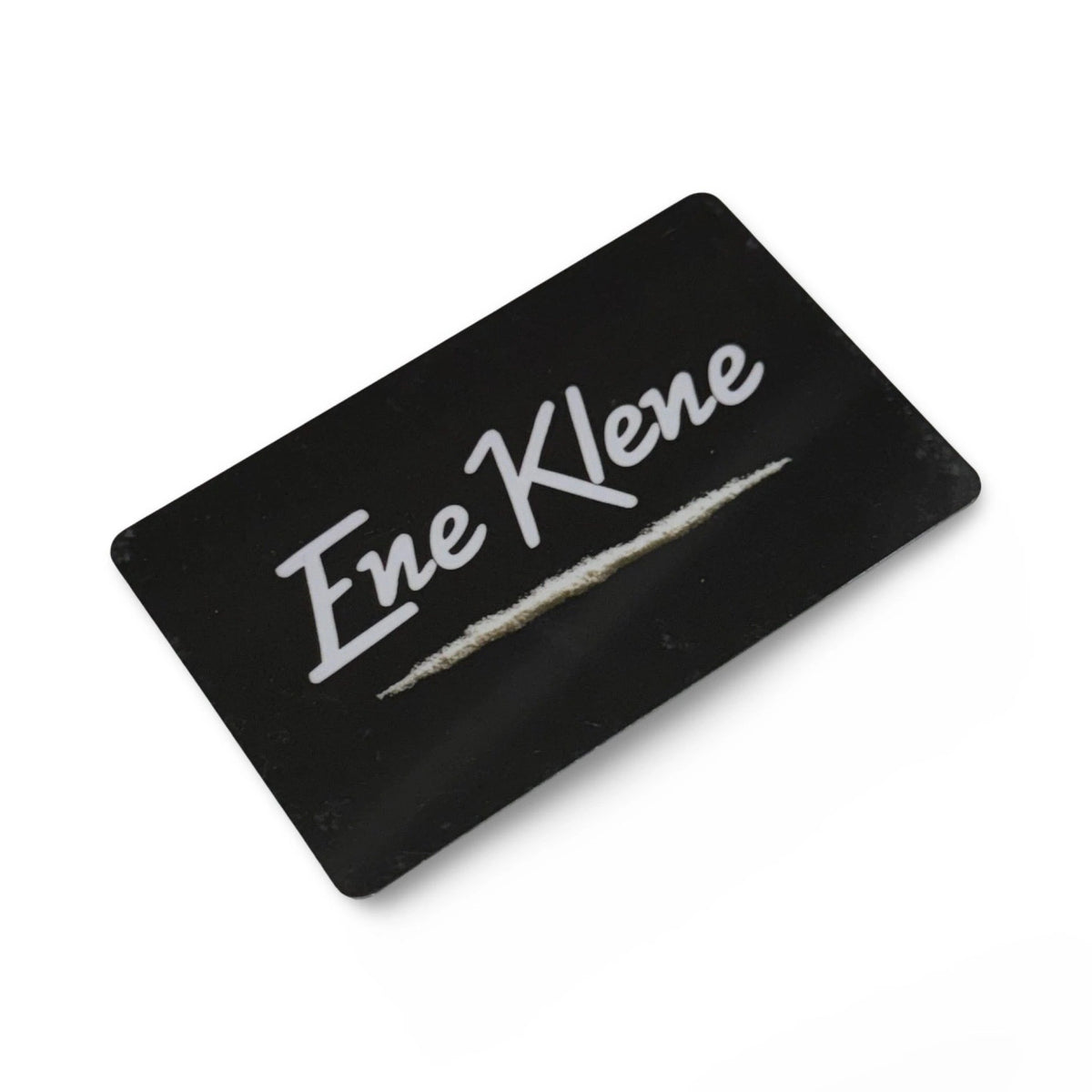 Schwarze Hack-Karte mit weißem „Ene Klene“-Schriftzug, diagonal auf weißem Hintergrund.