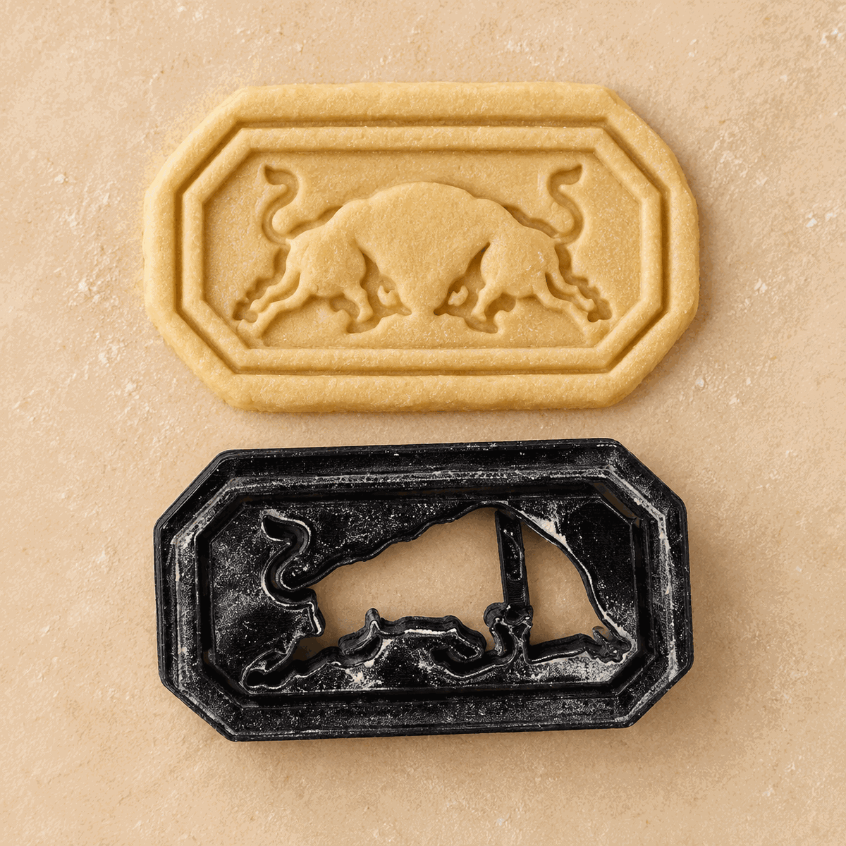 Keks mit zwei Stieren im Red-Bull-Motiv und passender schwarzer Keksausstecher darunter.